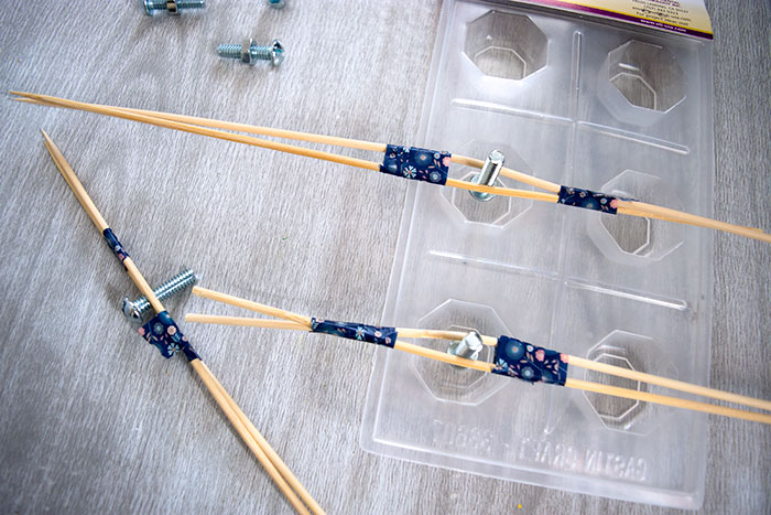 Hold the screws in place with sticks and tape