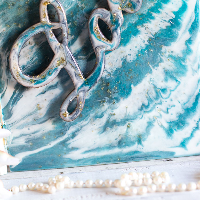 Detailed image of turquoise, white and gold poured resin on a wood surface