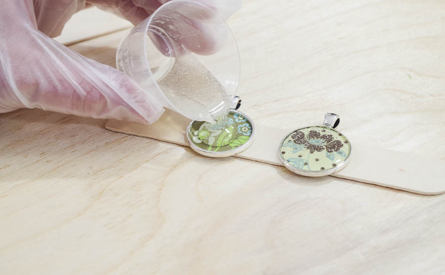 DIY paper and resin pendants - pour jewelry resin into the bezels over paper