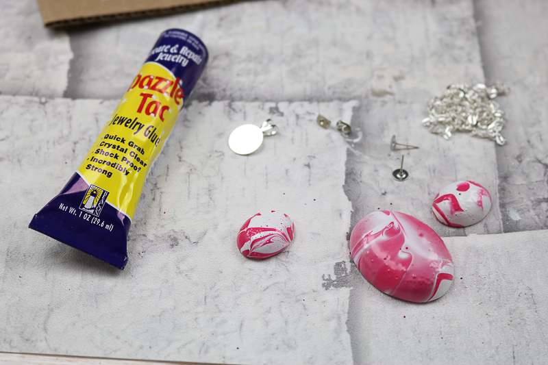 Using a jewelry glue on the back of an Easter egg necklace and earrings.