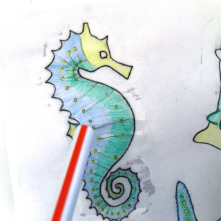 Remove air bubbles from paper embellishments by blowing through a straw