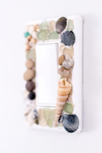Learn how to make your own beachy decorative switch plates with sea glass, stones and shells. An easy way to embellish those light switch covers for a coastal vibe!