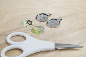 DIY paper and resin pendants - cut paper into circles to fit in bezels