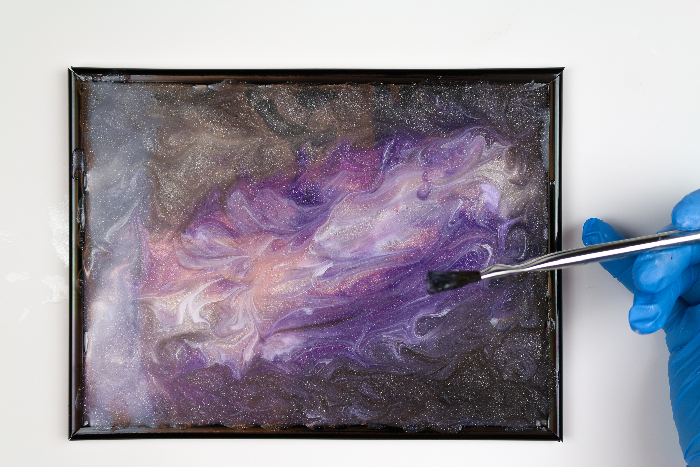 Galaxy Resin on a frame with a paintbrush
