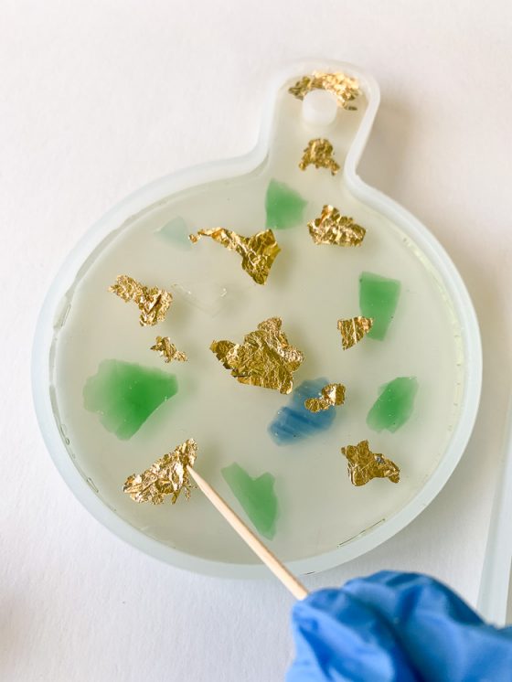 Place gold leaf flakes into the soft resin, and gently push the flakes down with a toothpick.