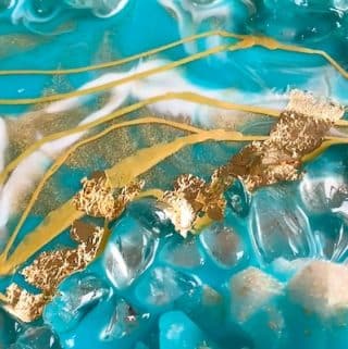 gold-foil-being-applied-to-a-geode-mirror-with-a-paintbrush