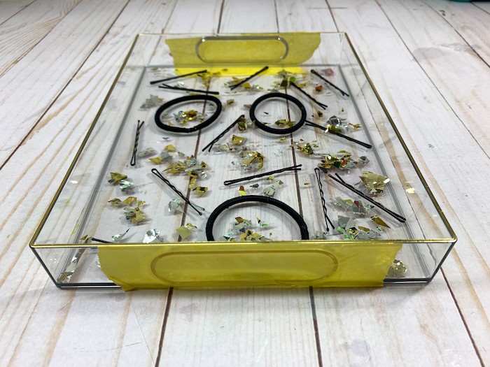 Learn how to make a clear resin tray filled with hair accessories! This is such a fun vanity tray.