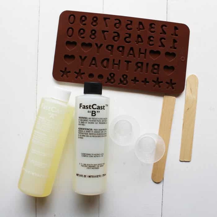 FastCast resin, mixing cups, stirring sticks, and disposable gloves plus a silicone alphabet or happy birthday mold is all it takes to create a cake topper.