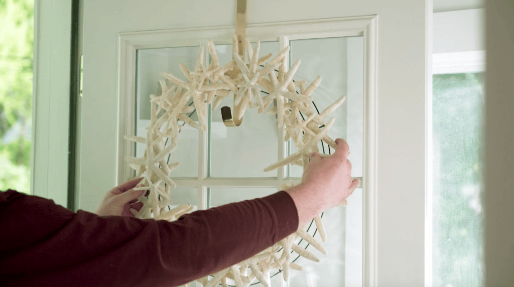 Completed starfish custom coastal wreath being displayed on a door.