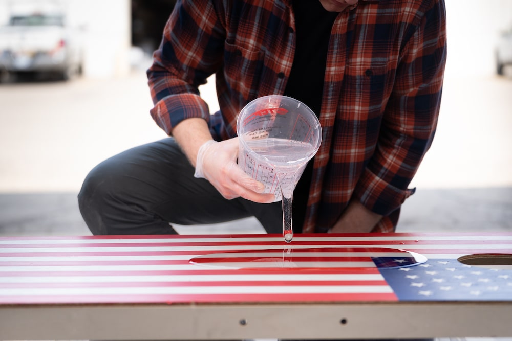 pouring amazing clear cast onto American flag custom cornhole board