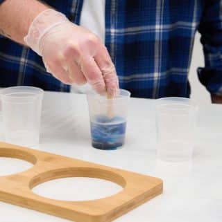 Mixing together resin and blue dye in a mixing cup.