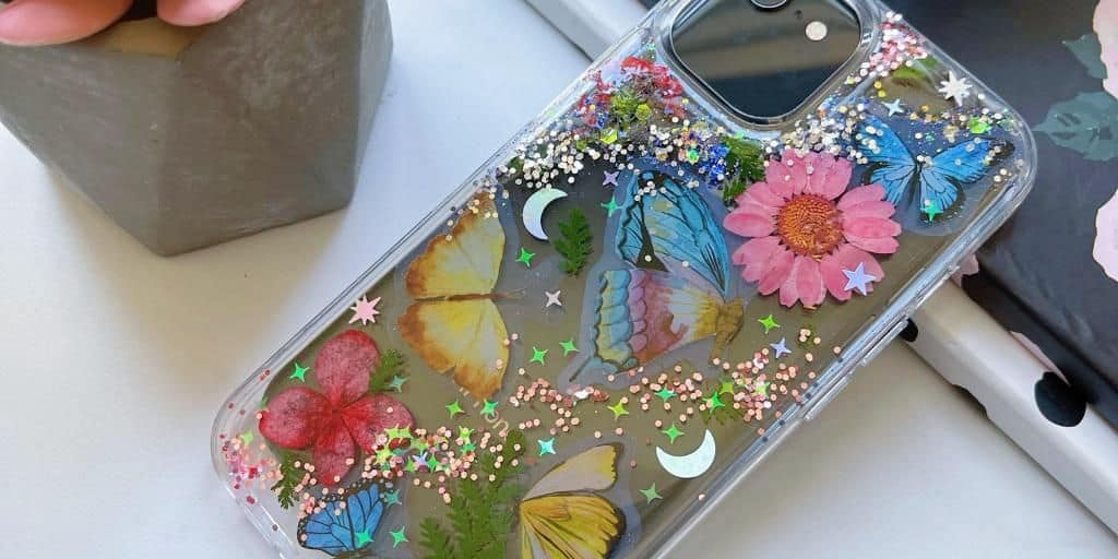 DIY resin phone case with glitter and stickers.