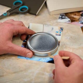 Mason jar lid being used to cut a circular photo.
