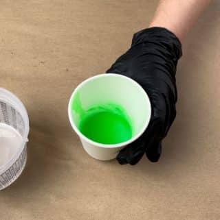 Glow in the dark powder and green resin dye mixed in a cup.
