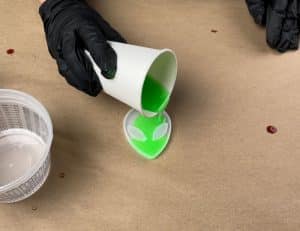 Resin dye and glow in the dark powder being poured into alien mold.
