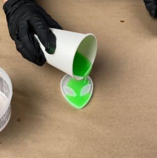 Resin dye and glow in the dark powder being poured into alien mold.
