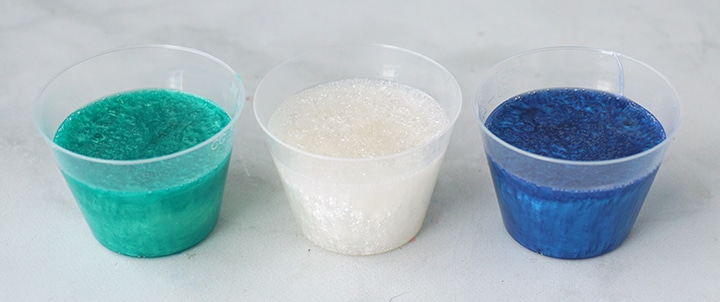 green, white, and blue resin in mixing cups
